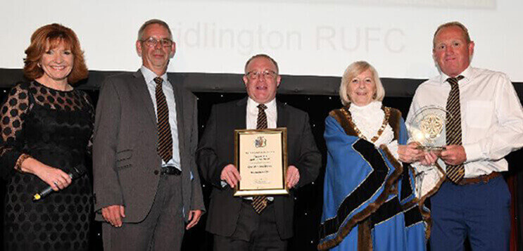 Bridlington Rugby Club’s Andrew Kempton and David Robinson and – hands on the trophy – Richard Medforth, with event host Clare Frisby and Council Chair Margaret Chadwick